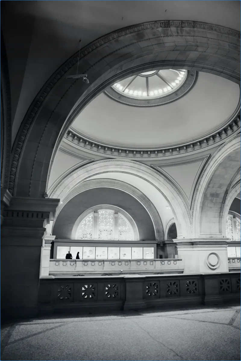 Interior of a grand building with arches and a dome.