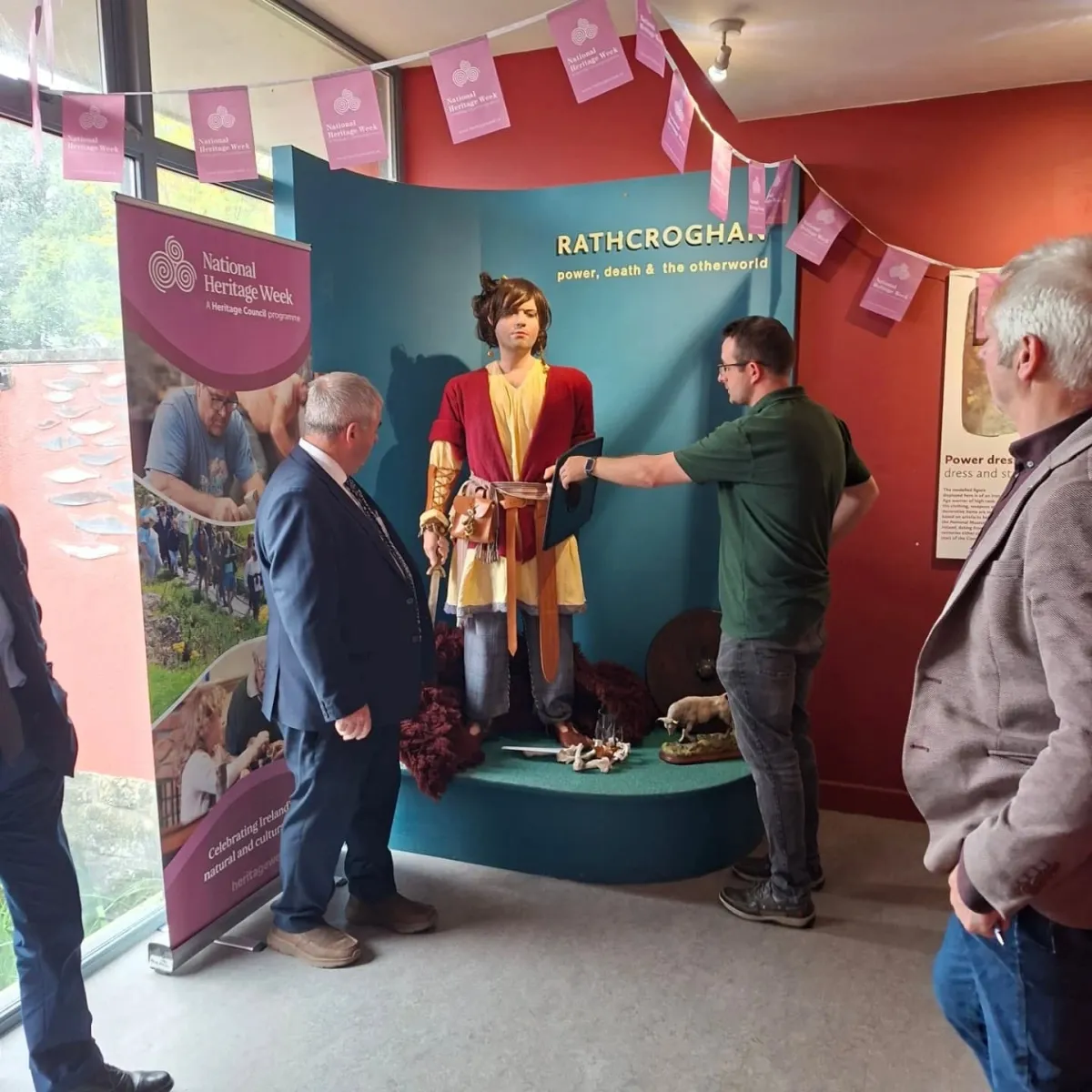 People observing a historical exhibit at Rathcroghan.